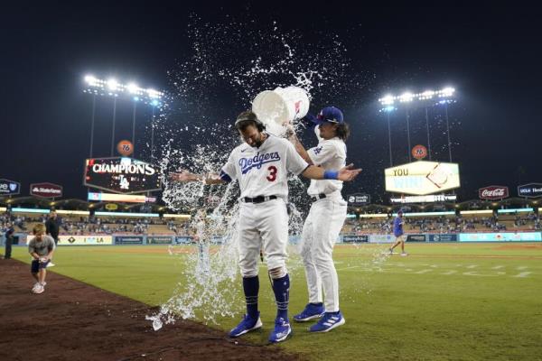 Los Angeles Dodgers' Chris Taylor, center, celebrates with teammates after hitting walk-off single to win a baseball game 3-2 against the San Francisco Giants in Los Angeles, Sunday, Sept. 24, 2023. Amed Rosario scored. (AP Photo/Ashley Landis)
