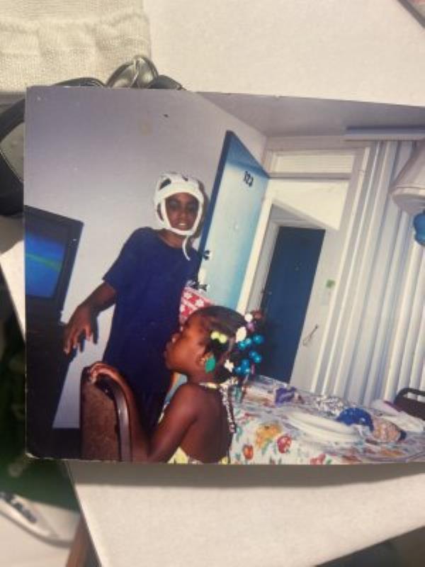 In this photo from childhood, Oro<em></em>nde McClain wears a protective helmet as he heals from a gunshot injury. At age 10, he was struck in the back of the head with a stray bullet that shattered his skull. Today, he remains partly paralyzed on his right side and still experiences seizures and PTSD. (Oro<em></em>nde McClain, Oro<em></em>nde McClain)