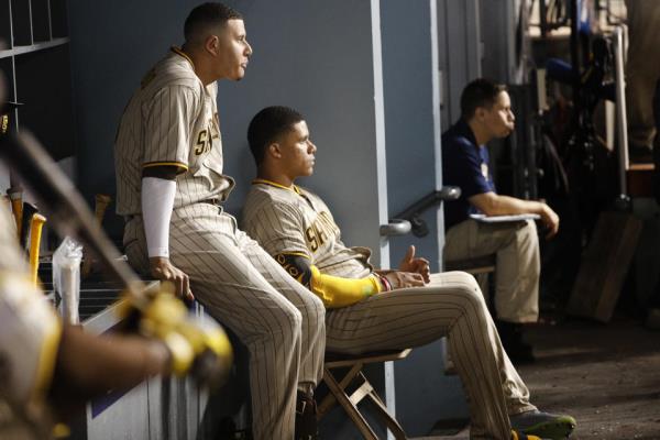 LOS ANGELES, CA - AUGUST 5, 2022:  Recently acquired San Diego Padre Juan Soto, right, sits in the dugout next to Padre Manny Machado during the game against the Dodgers at Dodger Stadium on August 5, 2022 in Los Angeles, California.(Gina Ferazzi / Los Angeles Times via Getty Images)