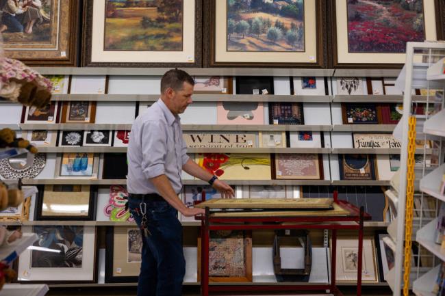 Paintings and illustrations pile up at the Savers thrift store in Manchester, N.H., in September 2023. A woman found a rare N.C. Wyeth illustration while rummaging though f<em></em>rames at a Savers in New Hampshire — now the piece is expected to draw a significant sum at auction. (Joe Klementovich/The New York Times)
