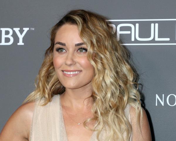 lauren co<em></em>nrad with curly hair on step-and-repeat